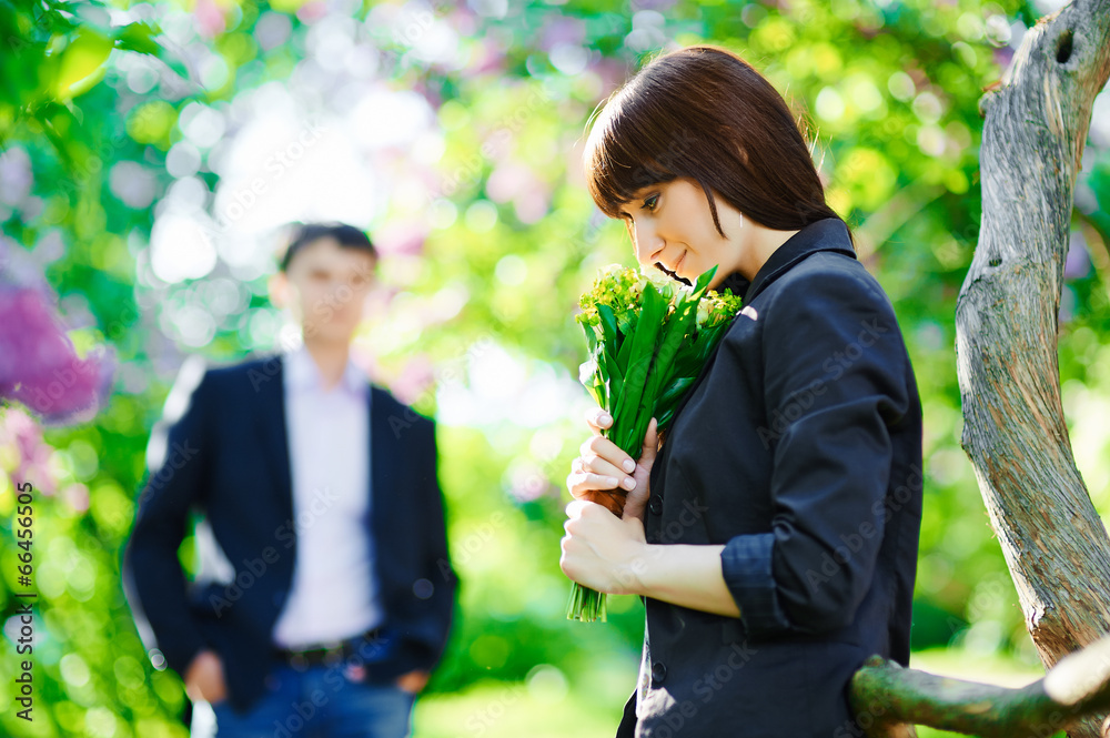 Young beautiful smiling woman smells small bouquet Young beautiful smiling woman smells small bouquet