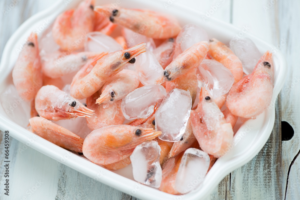 Iced shrimps in a glass bowl, close-up, high angle view Iced shrimps in a glass bowl, close-up, high angle view
