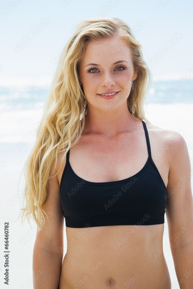 Fit blonde smiling at camera on the beach Fit blonde smiling at camera on the beach