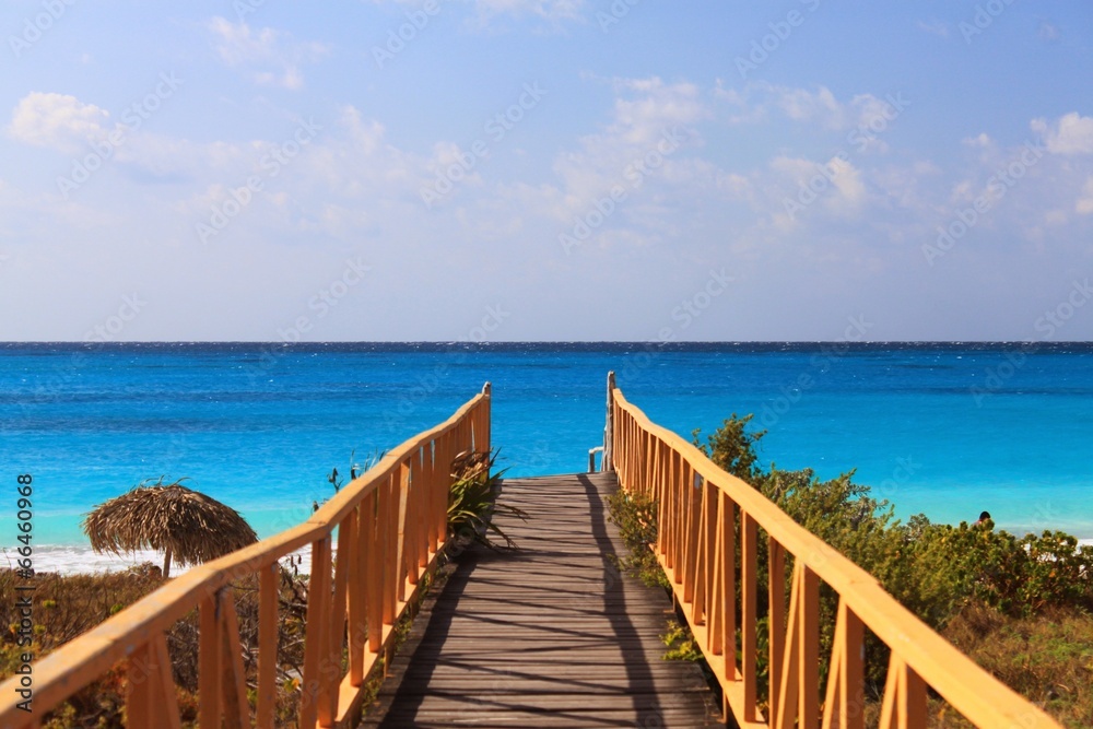 bridge leading to bright blue sea