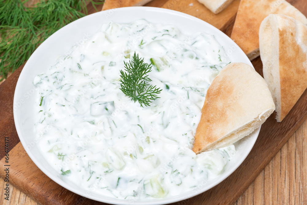 yoghurt sauce tzatziki with herbs, cucumber and garlic, top view yoghurt sauce tzatziki with herbs, cucumber and garlic, top view
