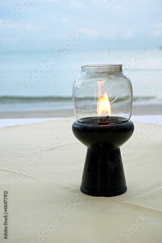 Fotografie candle lights up a table. Romantic dinner by the sea