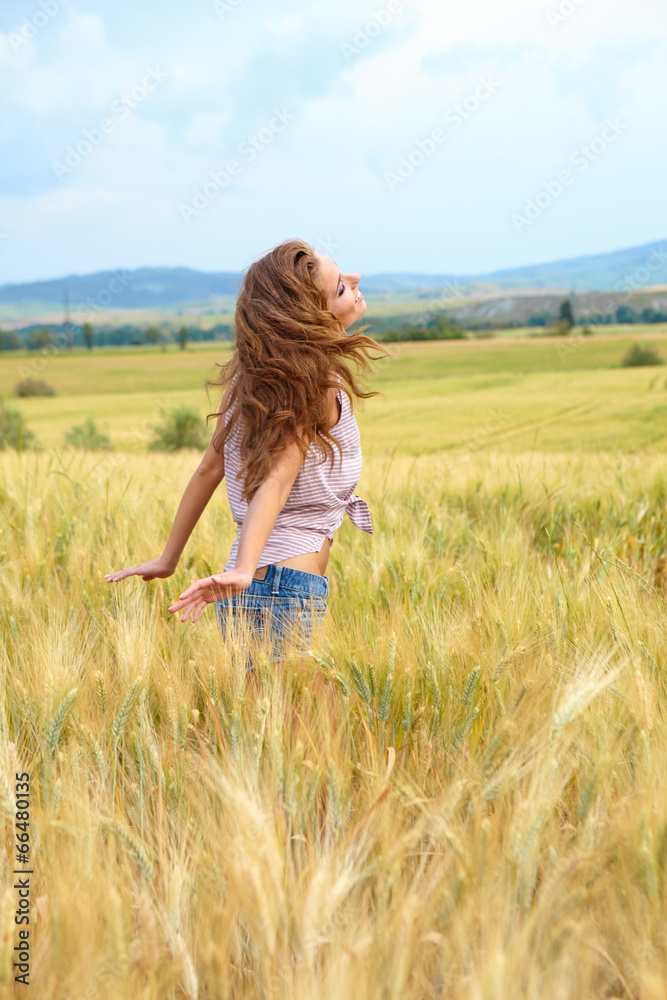 Beautiful woman walking on the field of grain. Tuscany. italy