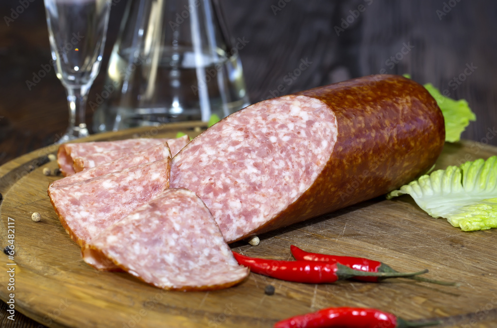 sausages on a wooden plate with vegetables in a restaurant sausages on a wooden plate with vegetables in a restaurant