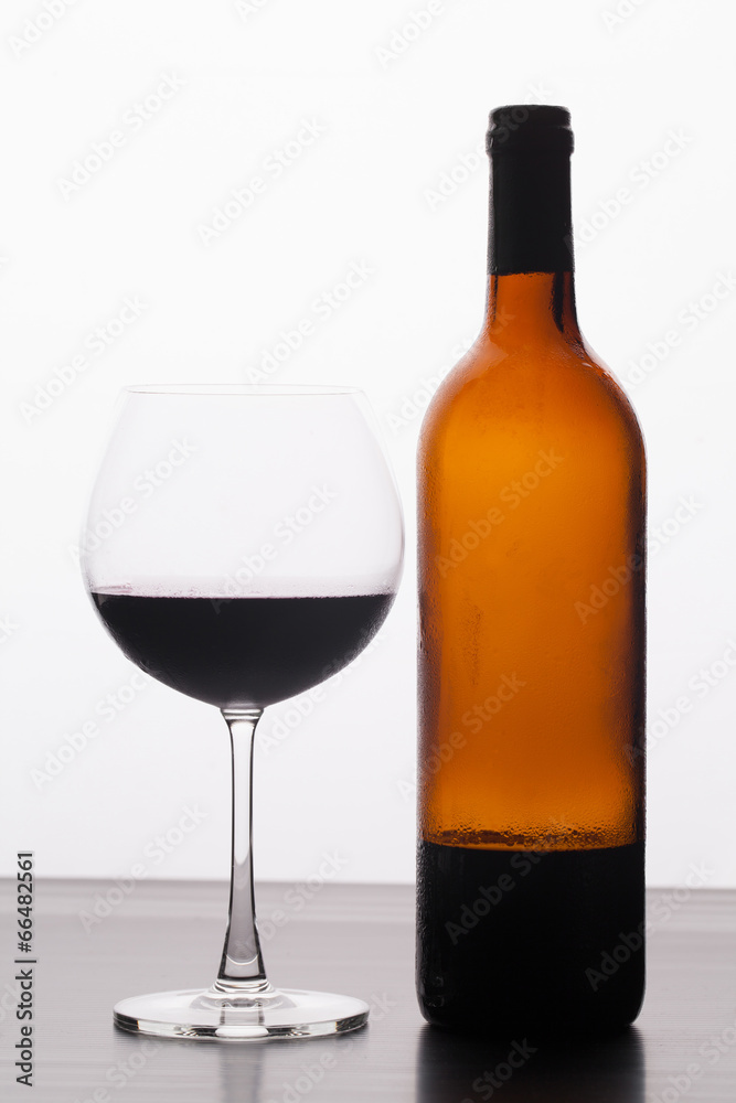 Glass and a bottle of red wine isolated on white background Glass and a bottle of red wine isolated on white background