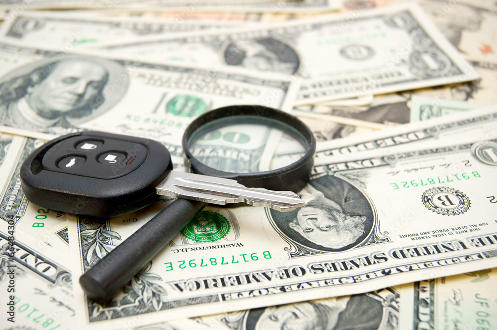 Keys from the car and a magnifier on money. Keys from the car and a magnifier on money.