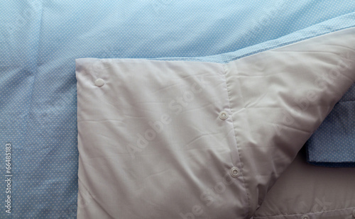 Closeup of a bed with blue linen in the bedroom