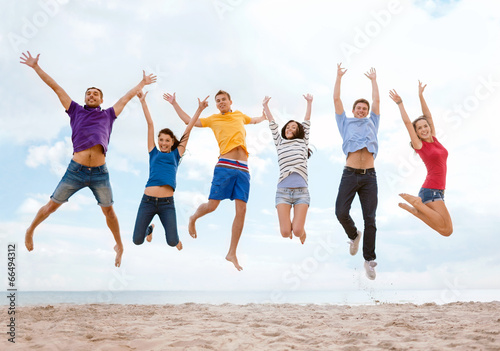 group of friends jumping on the beach