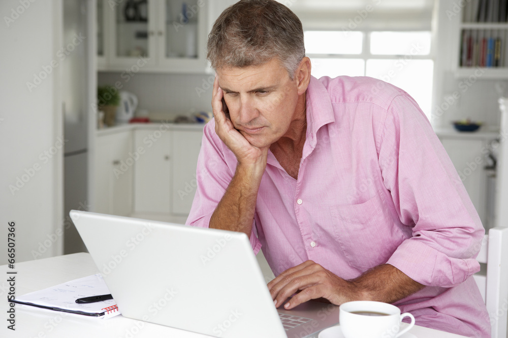 Naklejka premium Mid age man working on laptop at home