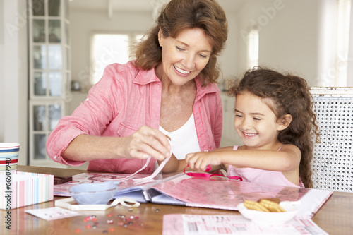 Senior woman scrapbooking with granddaughter photo