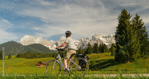 Fahrradfahrer betrachtet malerische Landschaft der Alpen