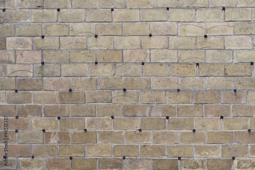 The creative gray brick wall with pig-iron rivets as background