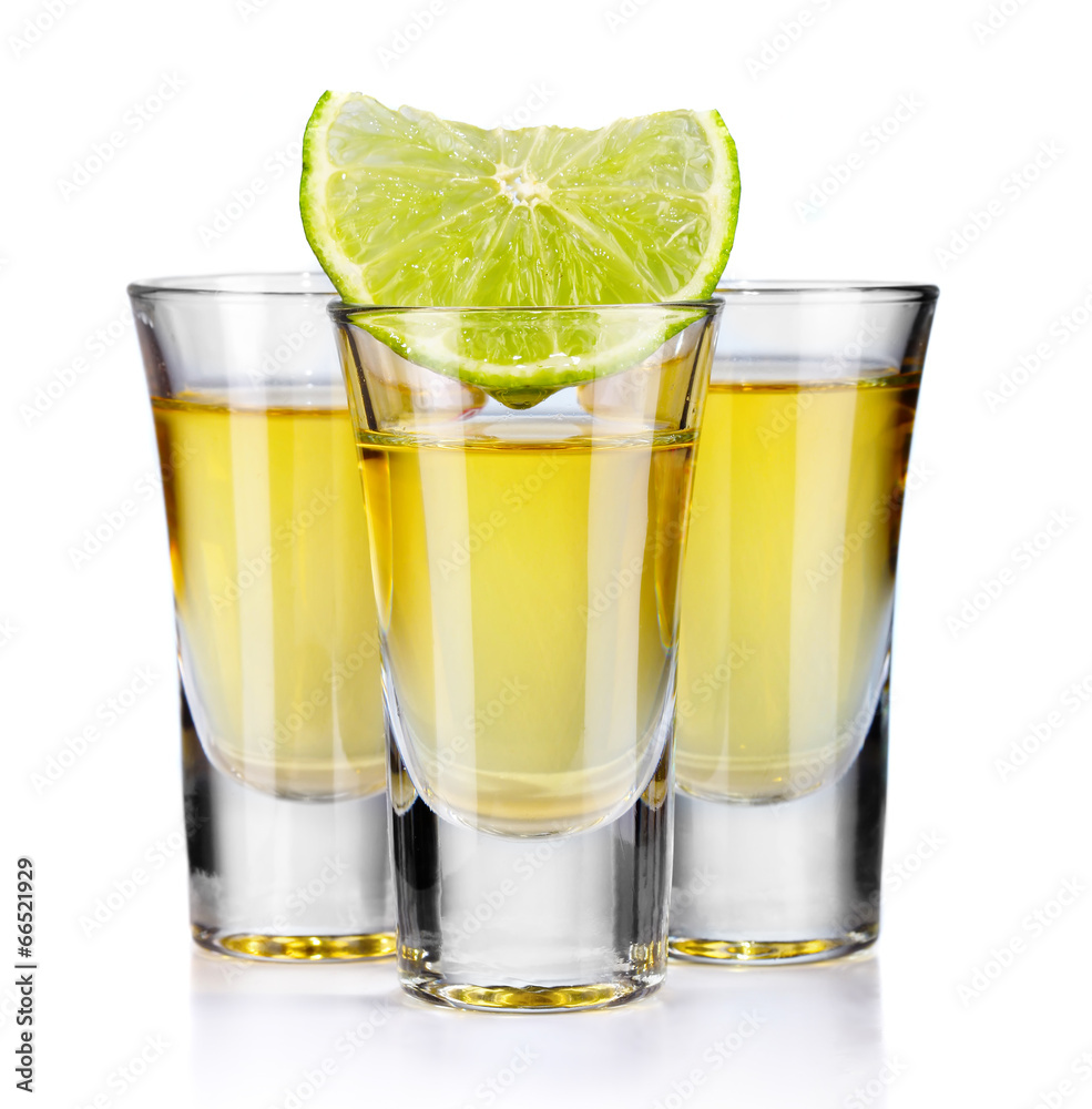 Three gold tequila shots with lime isolated on white