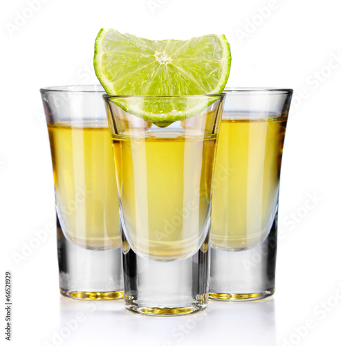 Obraz na płótnie Three gold tequila shots with lime isolated on white w salonie