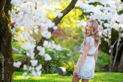 Beautiful woman in blooming cherry garden