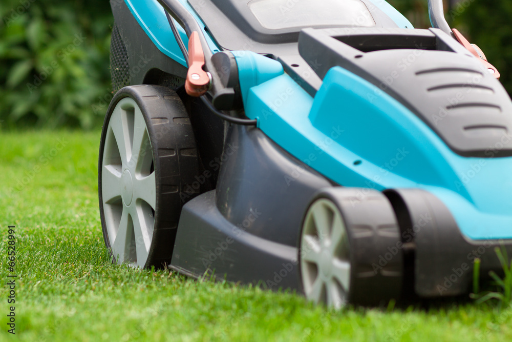 Detail of lawnmower on green grass