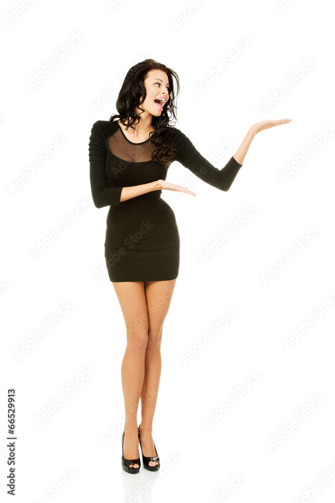 Woman in black dress presenting copy space Woman in black dress presenting copy space