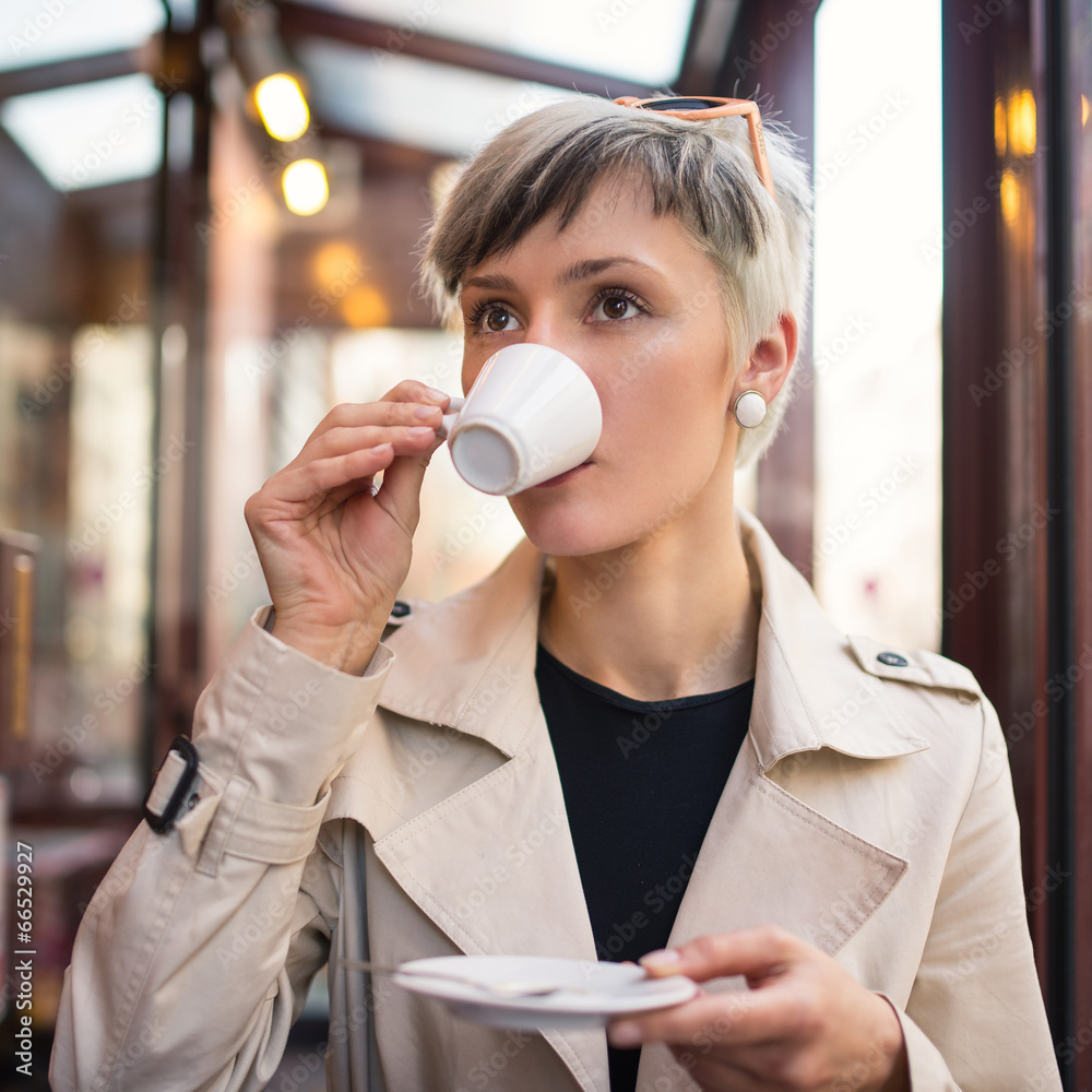 Young woman drinking coffee in a cafe in Paris, France. Shallow Young woman drinking coffee in a cafe in Paris, France. Shallow