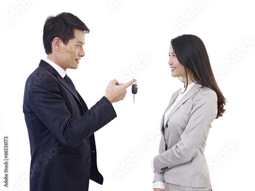 man handing car key to woman