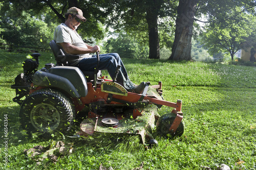 Landscaper cutting grass on riding lawn mower
