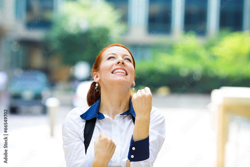 Businesswoman celebrating success outside corporate office Businesswoman celebrating success outside corporate office