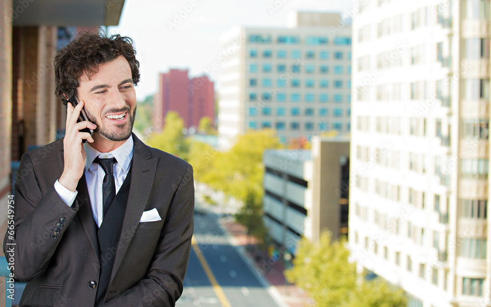 Businessman talking on phone on balcony of his hotel, apartment Businessman talking on phone on balcony of his hotel, apartment