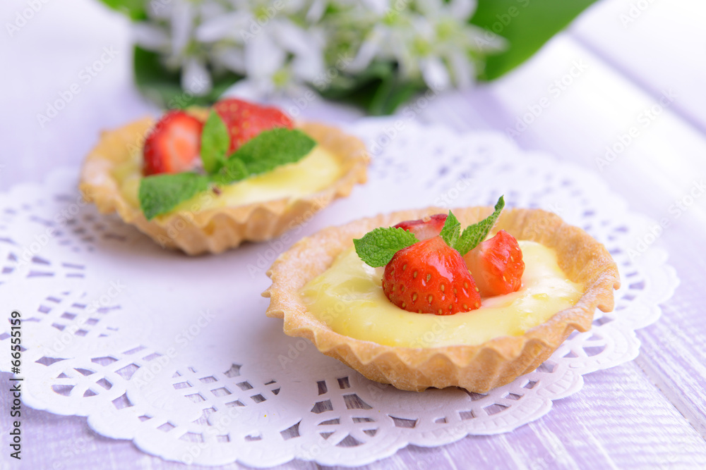 Tasty tartlets with strawberries on table close-up Tasty tartlets with strawberries on table close-up