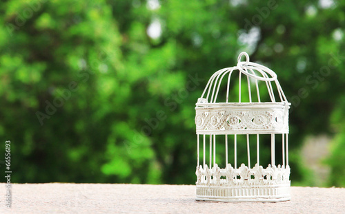 Fototapeta Naklejka Na Ścianę i Meble -  Empty white vintage birdcage  outdoors