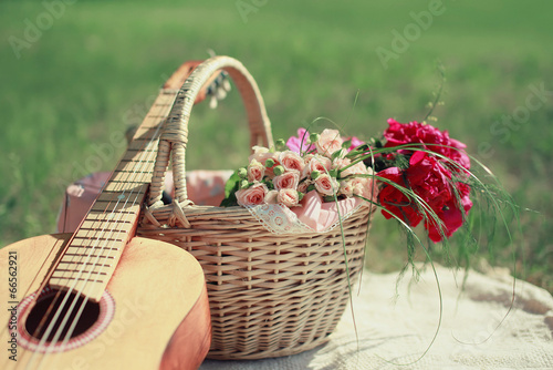Guitar  basket and bouquet of flowers. Vintage tender background