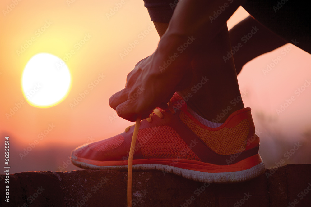  woman tying shoelaces outdoor - obrazy, fototapety, plakaty 