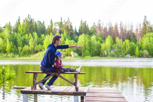 Young father and little girl fishing outdoor