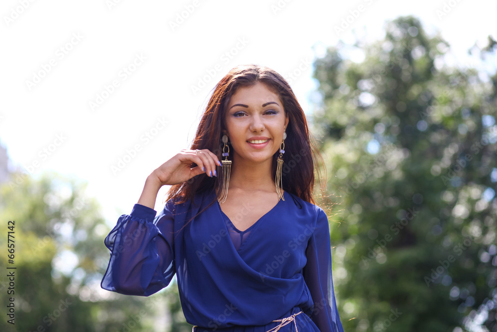 Happy young woman walking on the summer park