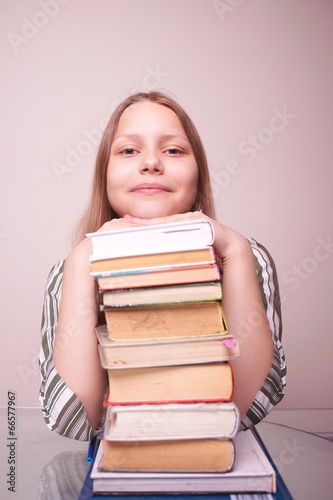 Happy teen girl sitting with books