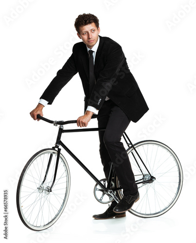 Attractive man in a classic suit with a bicycle on a white