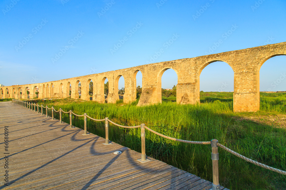 Old Greek aqueduct in warm sunset light in Larnaca, Cyprus
