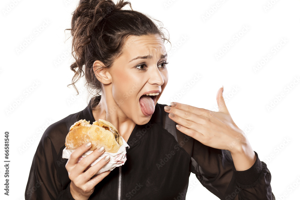 Young woman with spicy sandwich and burning tongue Young woman with spicy sandwich and burning tongue