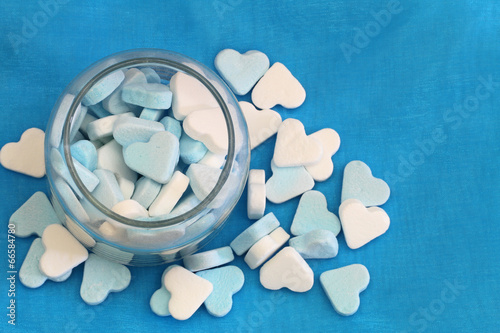 Blue and white sugar hearts on blue background with copy space