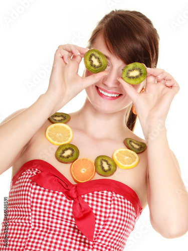 Girl in fruit necklace covering eyes with kiwi