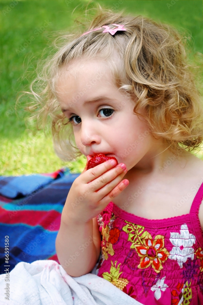 Girl in a summer eating fresh strawberries Girl in a summer eating fresh strawberries