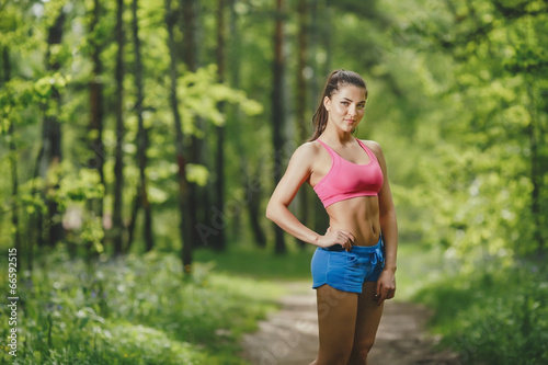 Fitness woman runner relaxing after forest running and work out
