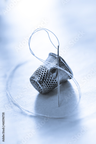 Bild auf Leinwand Sewing thimble and needle with thread