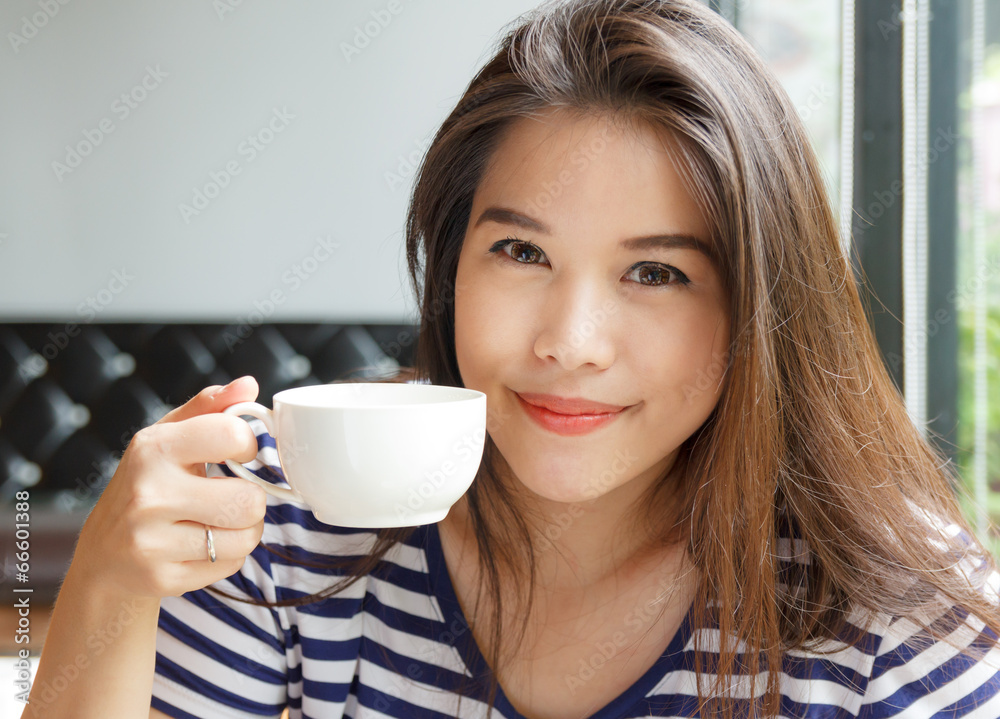 Portrait of asian woman smiling and holding  cup of coffee .