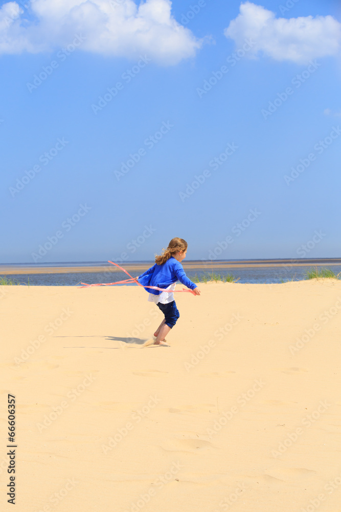 Young girl jumping on a sandy beach