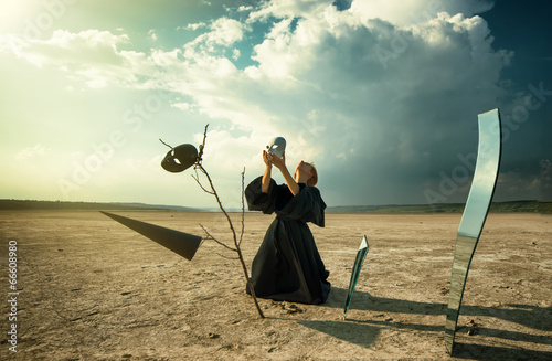 Woman putting a mask on her face in desert
