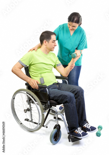 Physical therapist works with patient in lifting hands weights. © manaemedia