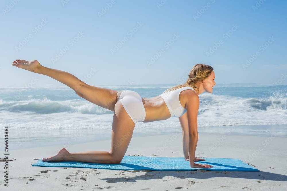 Gorgeous fit blonde in pilates pose on the beach Gorgeous fit blonde in pilates pose on the beach