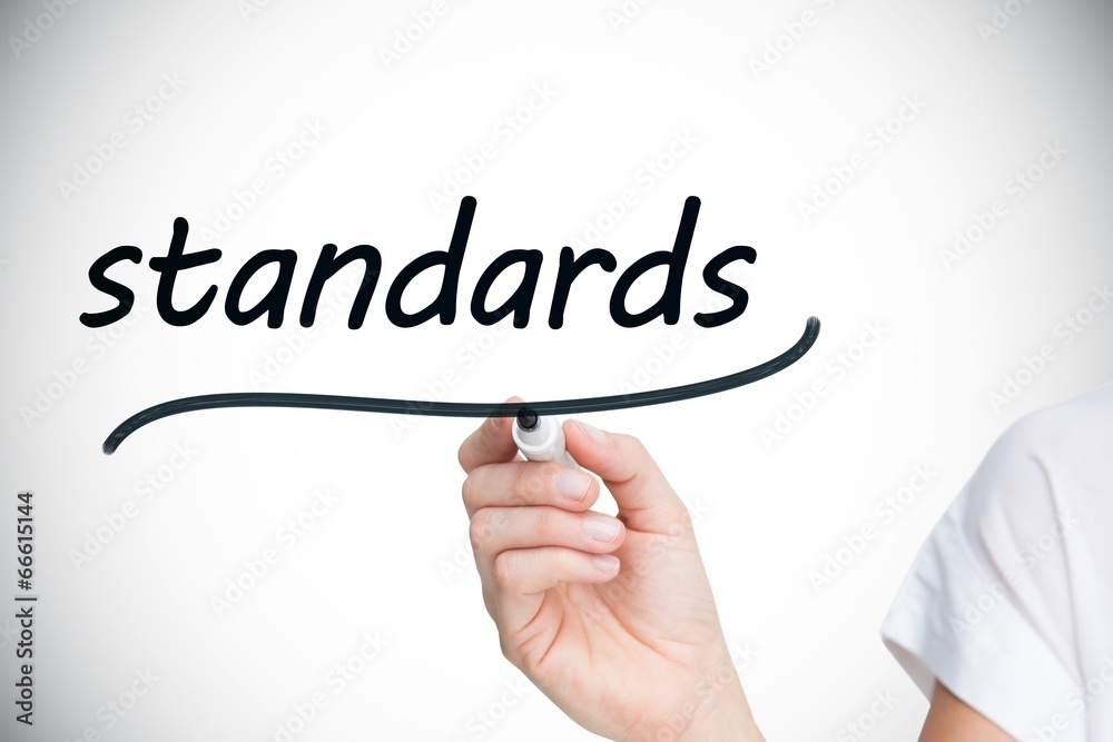 Businesswoman writing the word standards Businesswoman writing the word standards