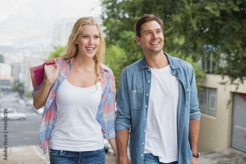 Obraz premium Hip young couple on shopping trip walking uphill