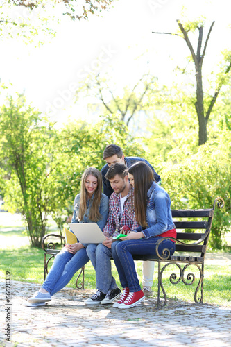 Happy students sitting in park