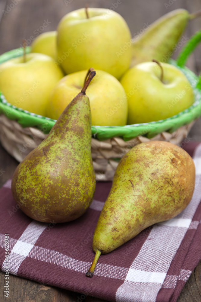 Fresh green apples and pears on a wooden table